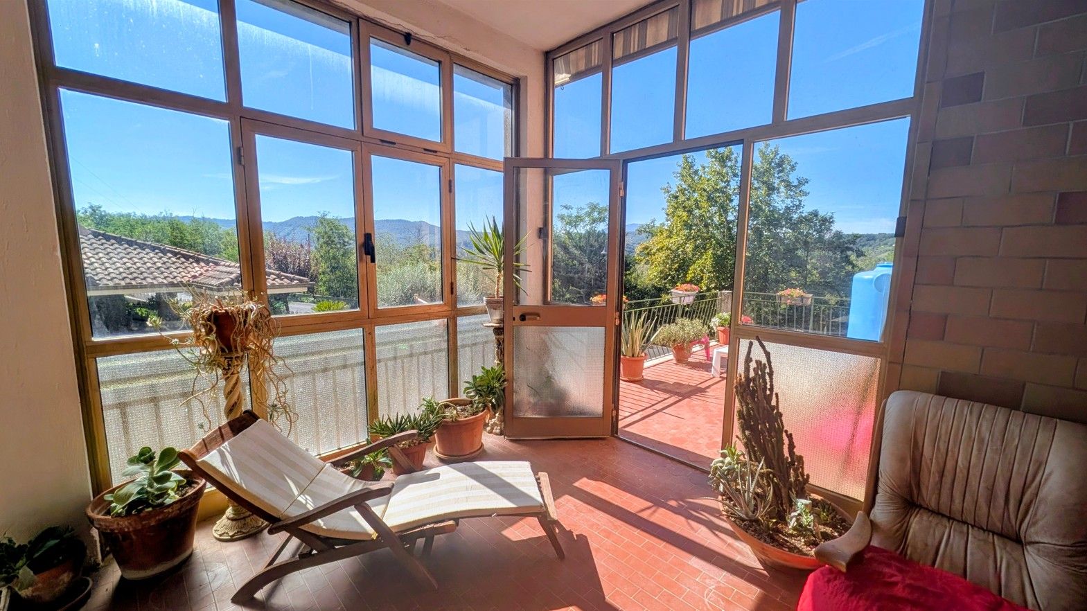 The glass veranda of the retreat house, looking out over the wooded hills